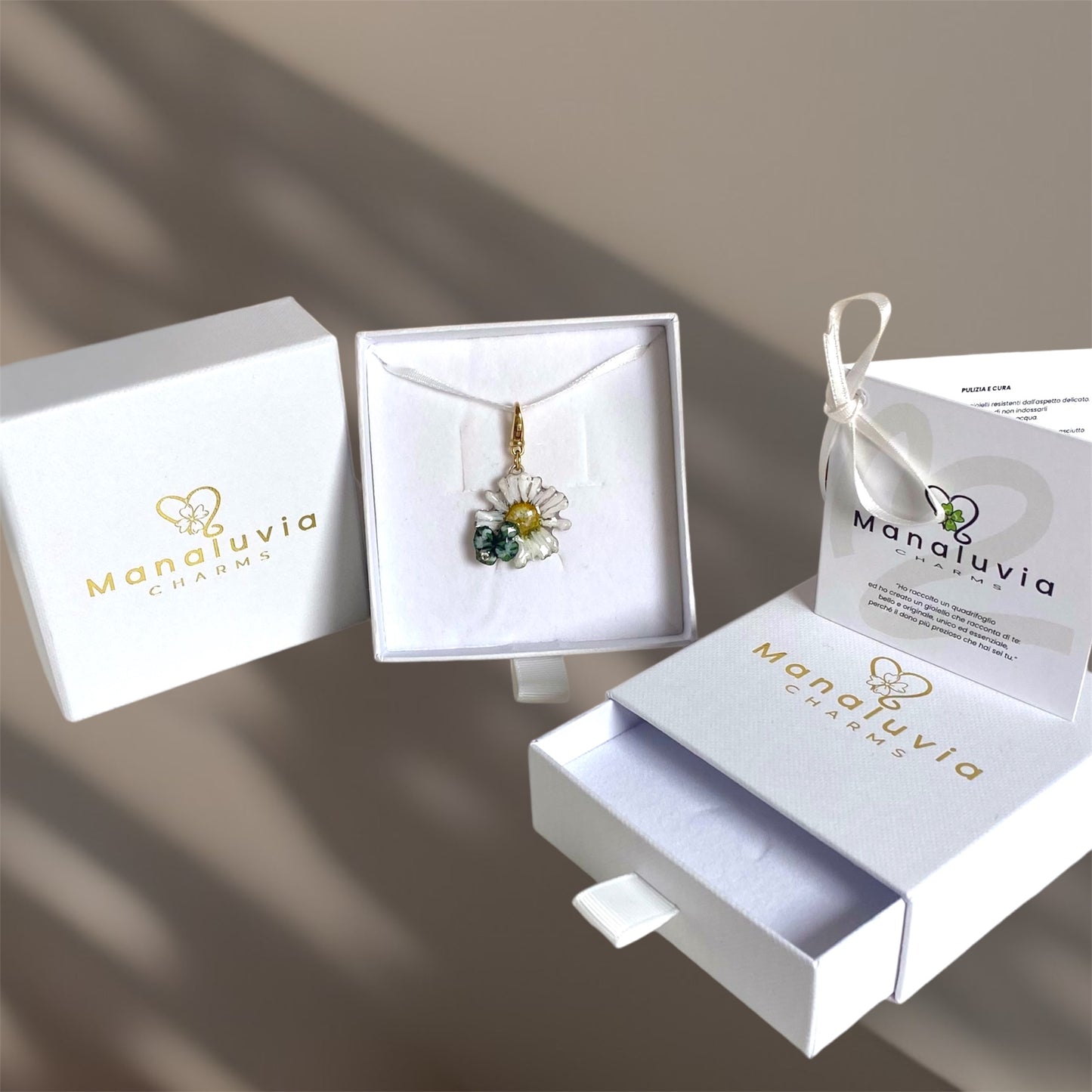 Charm portafortuna con un vero quadrifoglio e margherita, gancio in argento dorato.