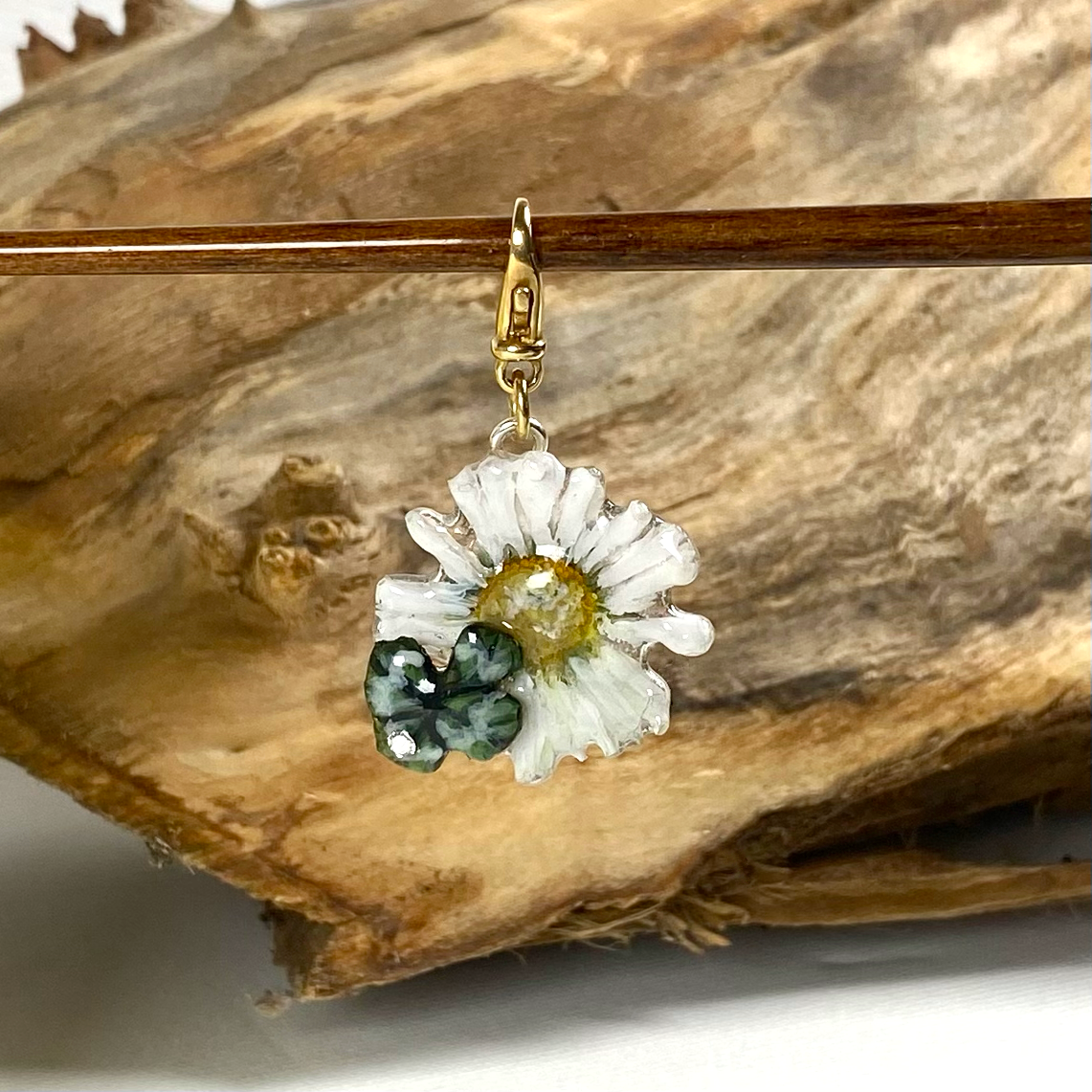 Charm portafortuna con un vero quadrifoglio e margherita, gancio in argento dorato.
