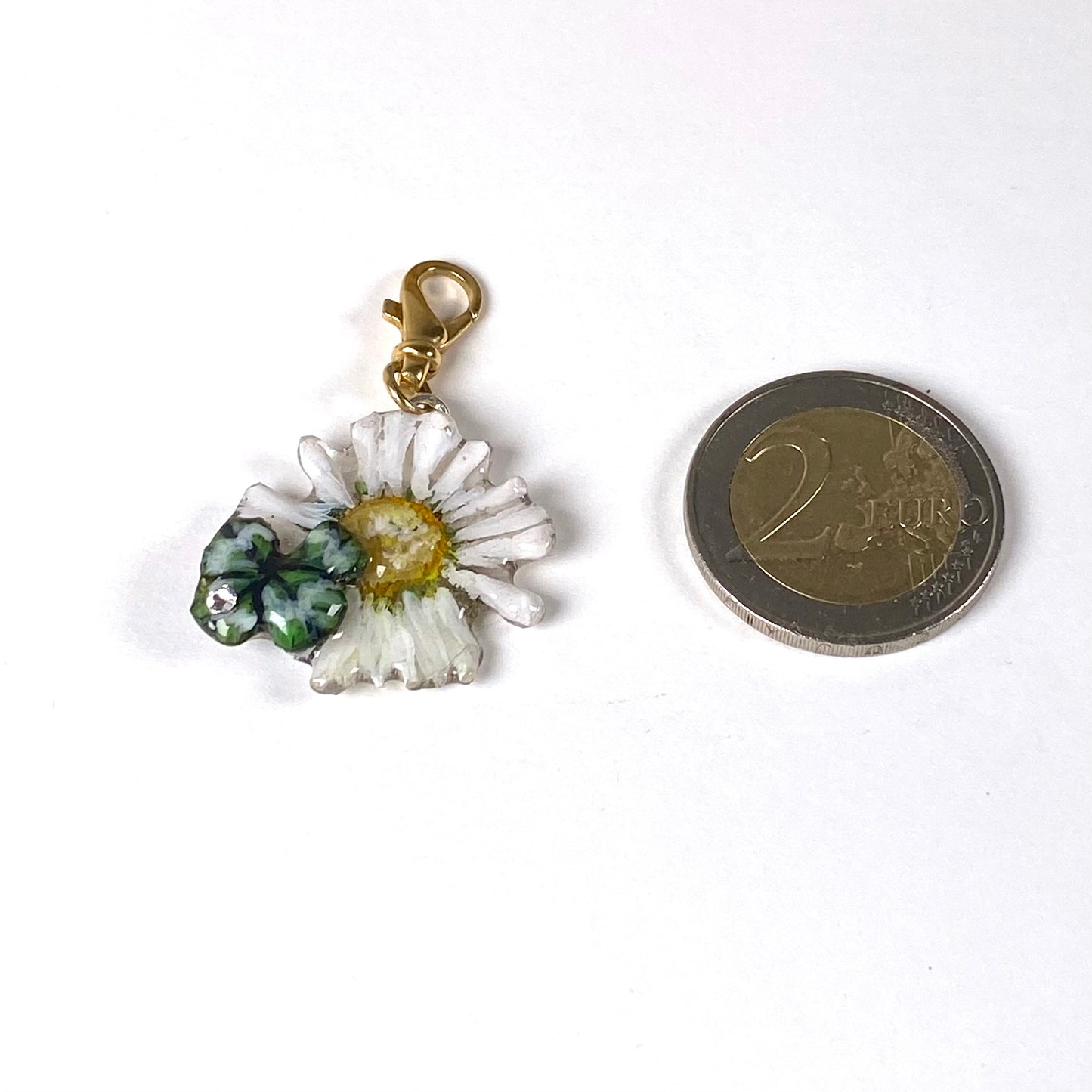 Charm portafortuna con un vero quadrifoglio e margherita, gancio in argento dorato.