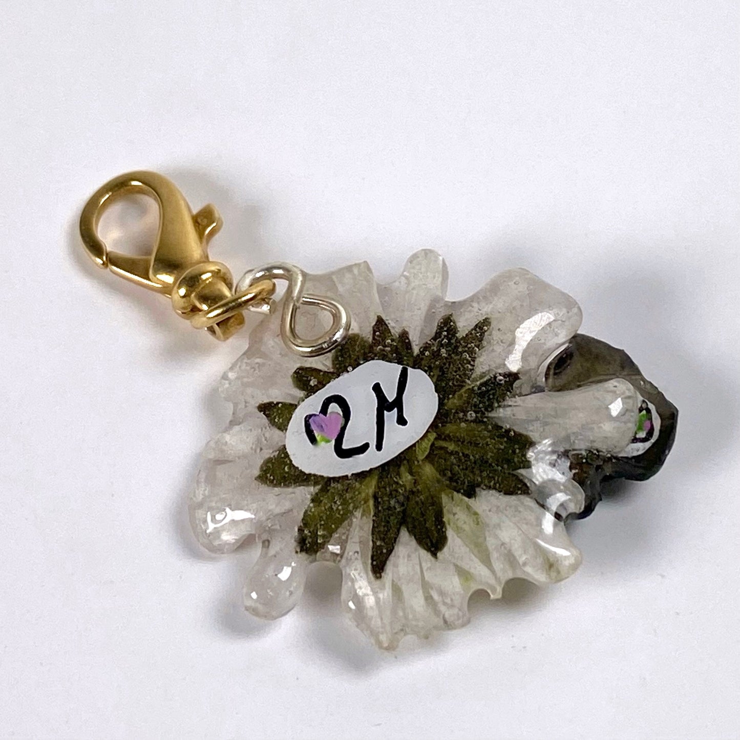 Charm portafortuna con un vero quadrifoglio e margherita, gancio in argento dorato.