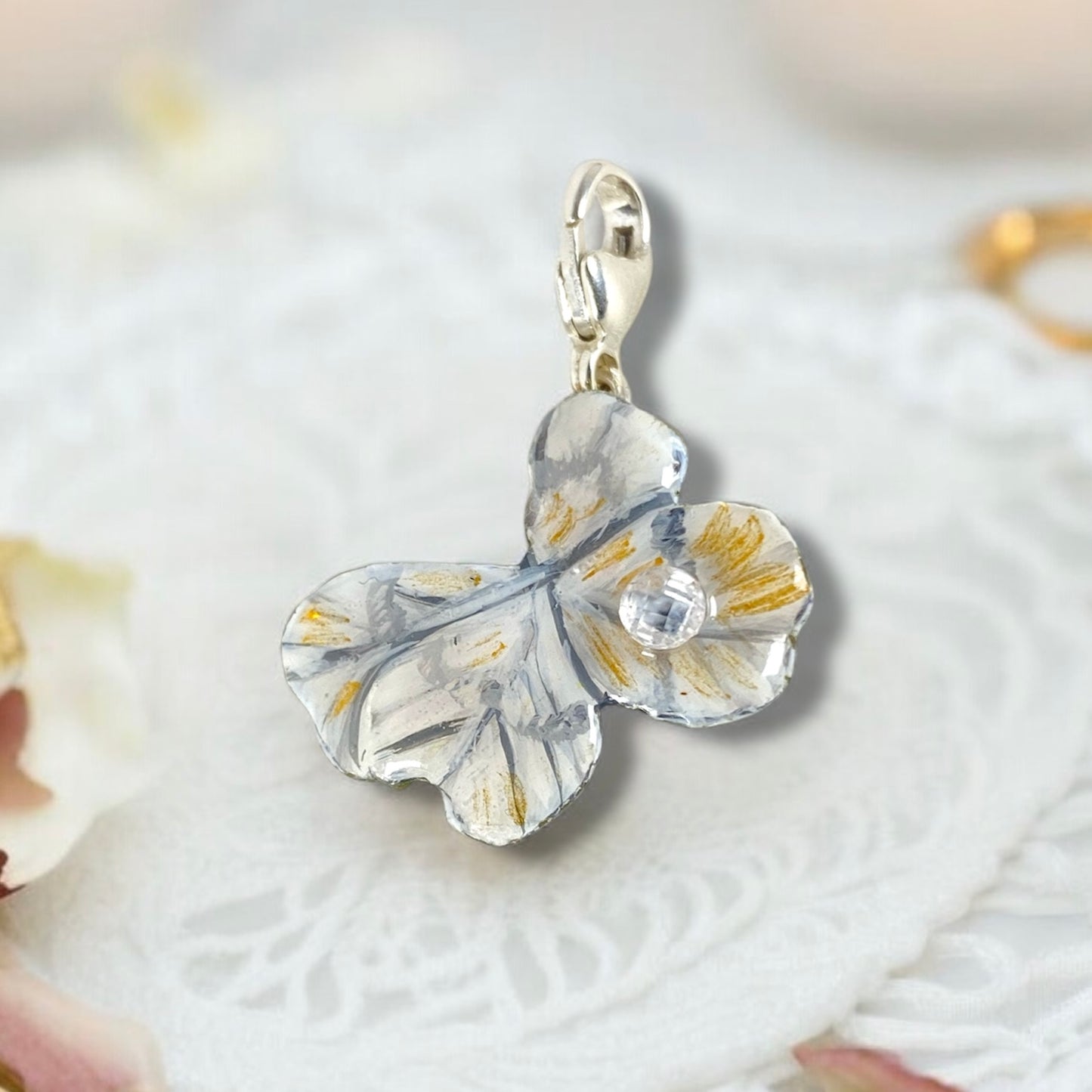 Chakra, charm quadrifoglio dipinto di bianco e oro, con perlina di zircone.