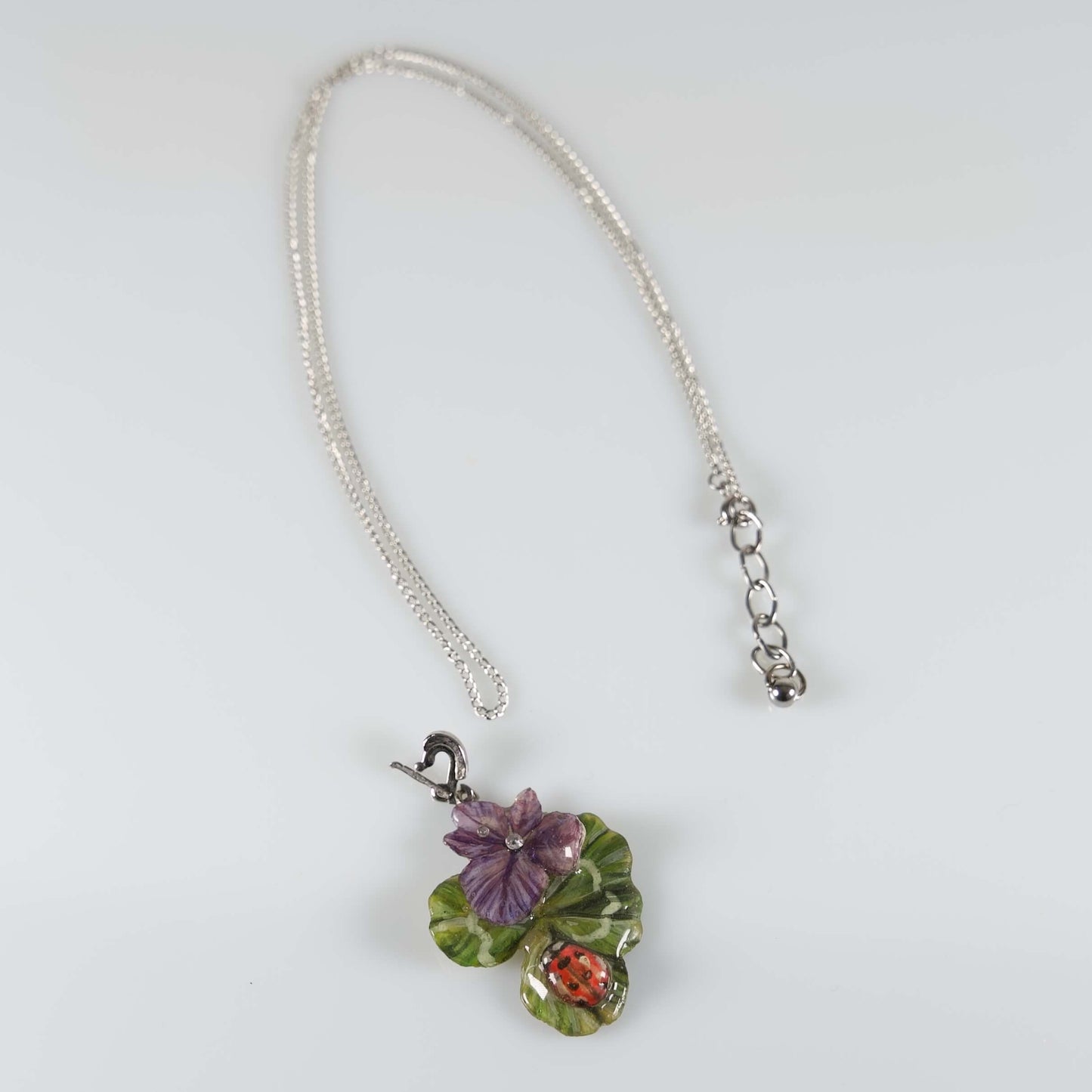 Collana con ciondolo con quadrifoglio e fiori