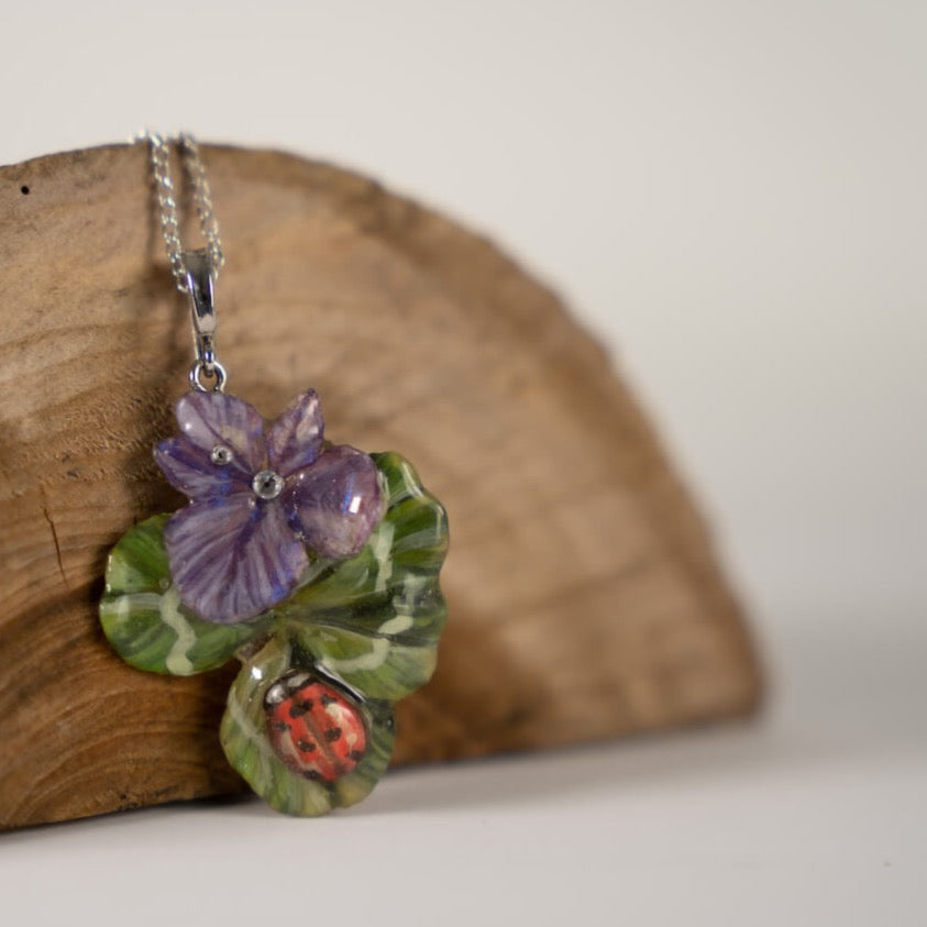 Collana con ciondolo con quadrifoglio e fiori