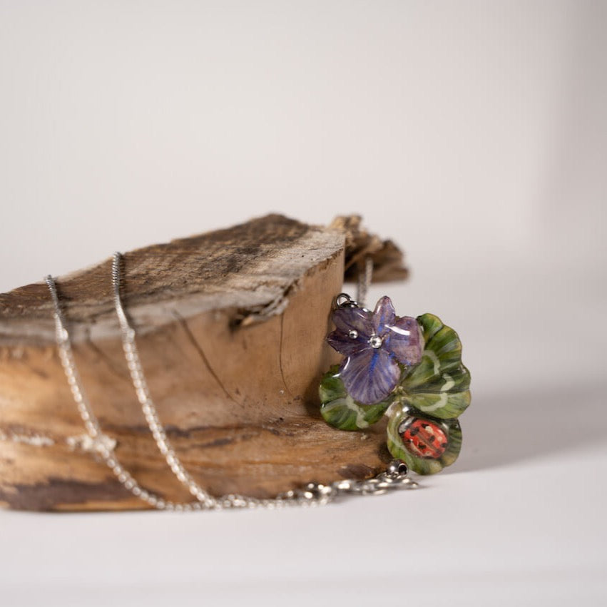 Collana con ciondolo con quadrifoglio e fiori