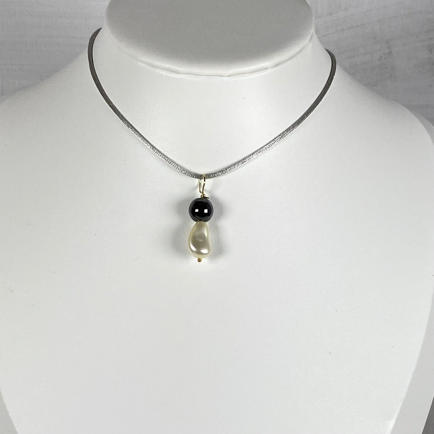 Ciondolo con perla Swarovski e perla di ematite con gancio in argento dorato. An1