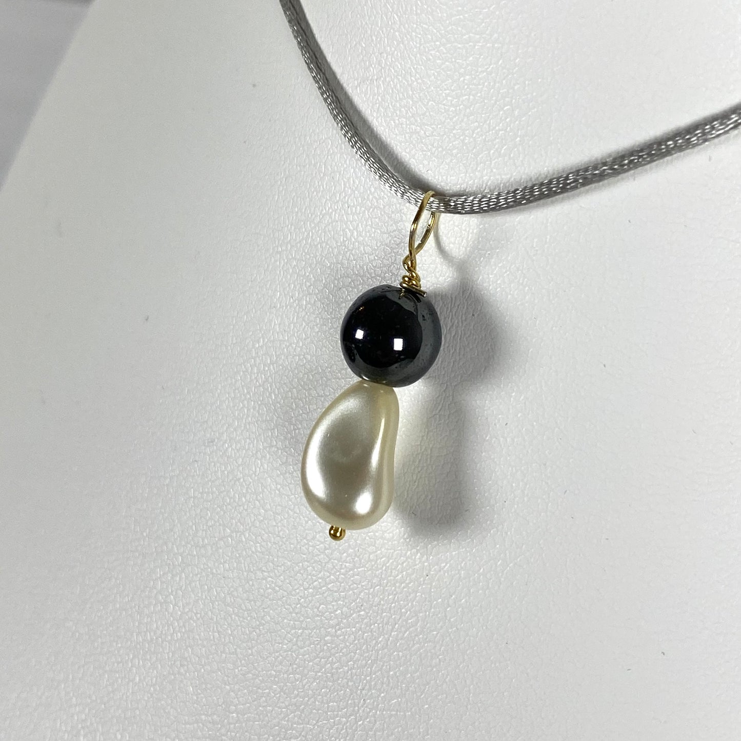 Ciondolo con perla Swarovski e perla di ematite con gancio in argento dorato. An1