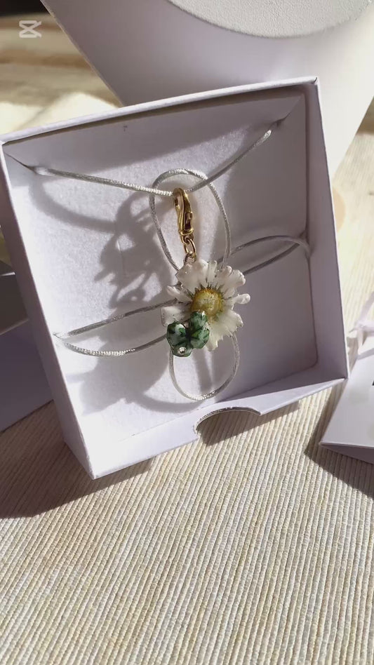 Charm portafortuna con un vero quadrifoglio e margherita, gancio in argento dorato.