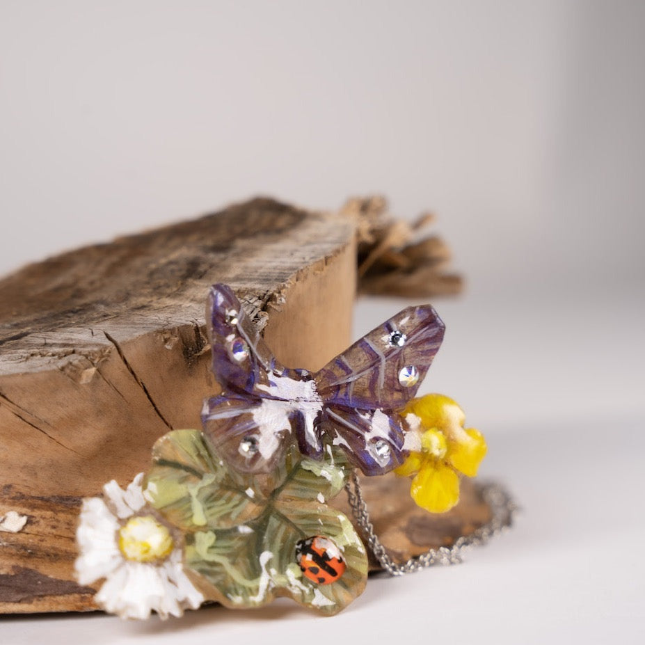 Gioiello artigianale in resina con fiori, farfalla e vero quadrifoglio –  Manaluvia